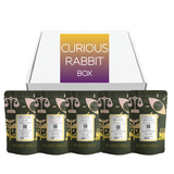 Rabbit Hole Roasters Curious Rabbit Box with five specialty coffee bags in front of a white subscription-style gift box.
